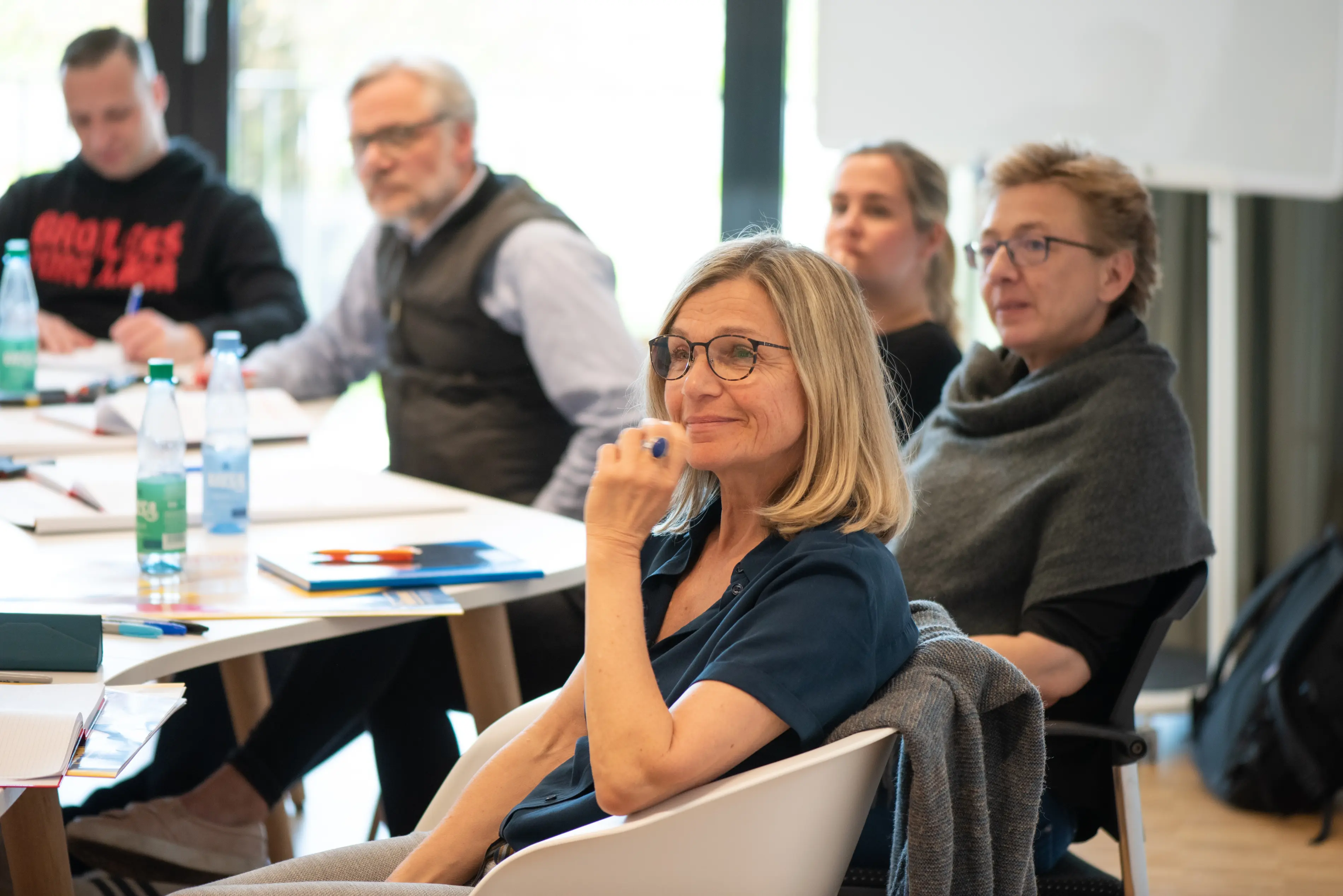 Am Tisch sitzende Gruppe von Teilnehmer:innen beim Seminar